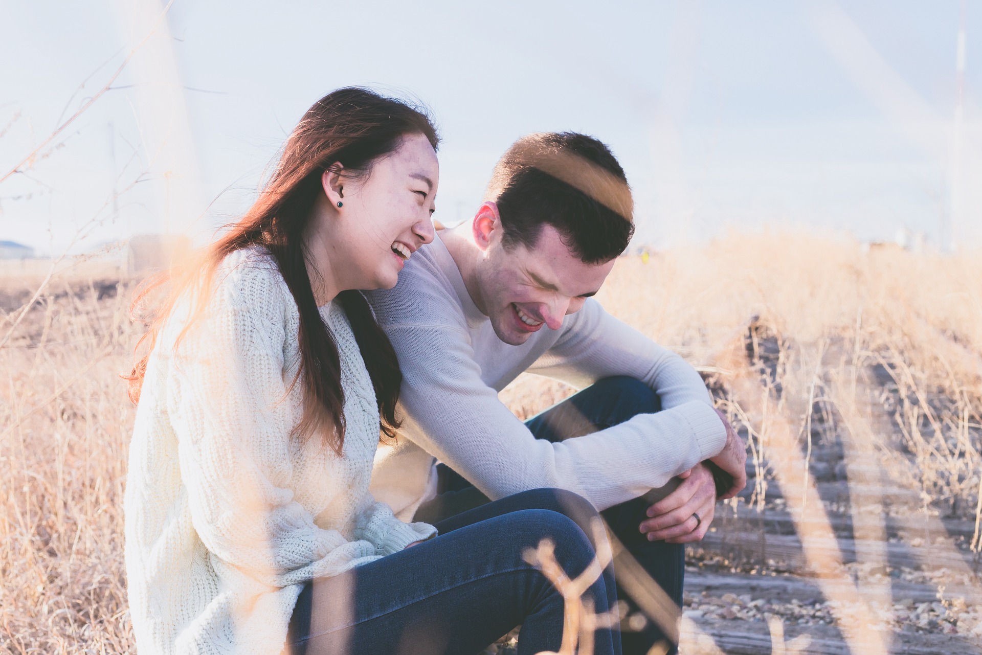 外に座り談笑している日本人女性と白人男性の画像